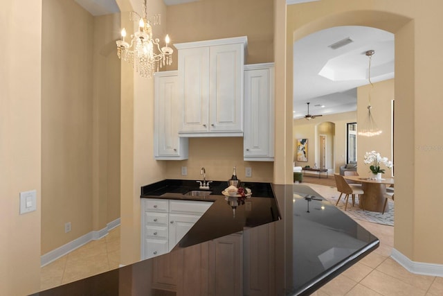 kitchen featuring light tile patterned floors, decorative light fixtures, and white cabinets