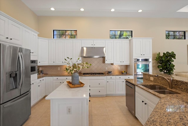 kitchen featuring light stone counters, stainless steel appliances, sink, and plenty of natural light