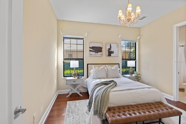 bedroom with dark hardwood / wood-style floors and a chandelier