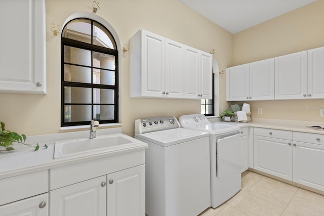 laundry room featuring cabinets, light tile patterned flooring, sink, and washing machine and clothes dryer