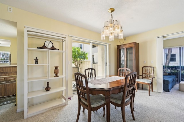 carpeted dining area with a chandelier