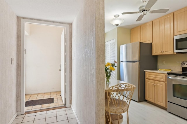 kitchen with ceiling fan, light brown cabinets, light tile patterned floors, and stainless steel appliances