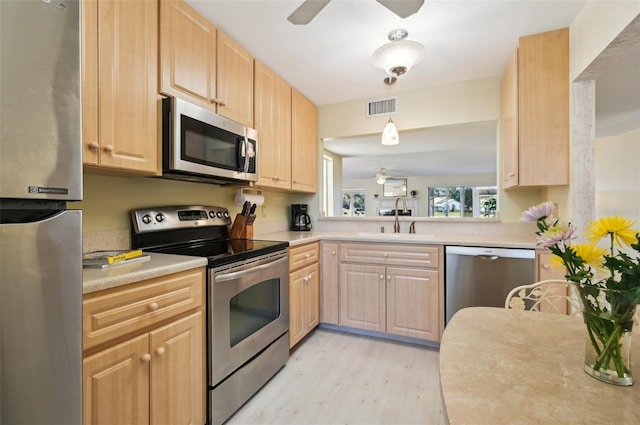 kitchen featuring light brown cabinetry, sink, and appliances with stainless steel finishes