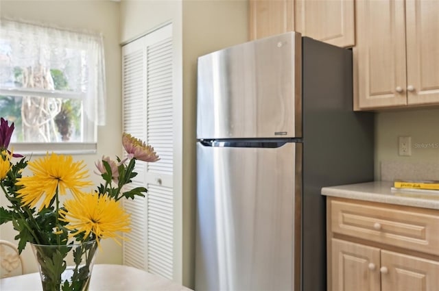 kitchen featuring stainless steel refrigerator and light brown cabinetry