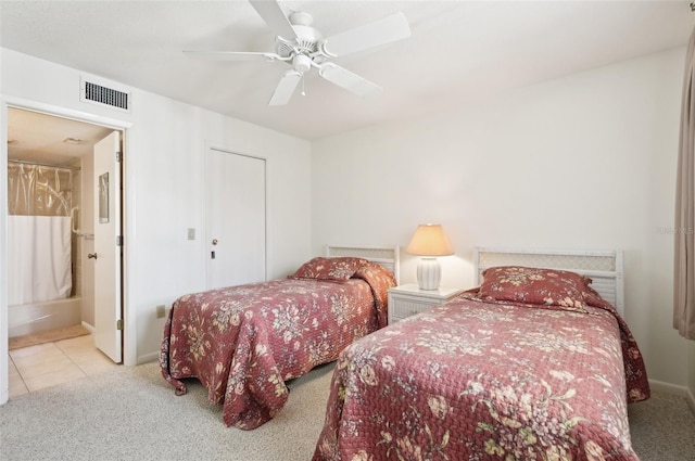 bedroom featuring ensuite bathroom, ceiling fan, and light tile patterned flooring