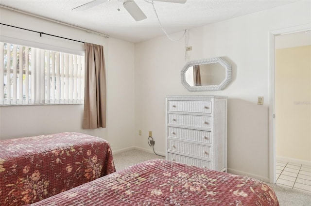 bedroom with a textured ceiling, ceiling fan, and light carpet