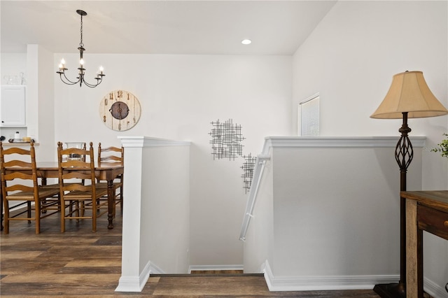 stairs featuring hardwood / wood-style flooring and a notable chandelier