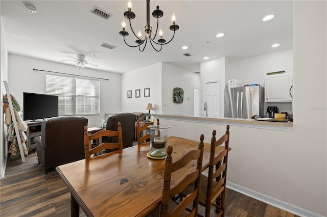 dining room with dark hardwood / wood-style floors and ceiling fan with notable chandelier