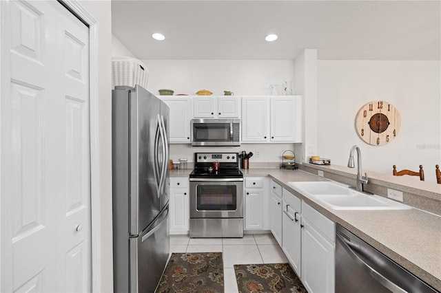 kitchen with white cabinets, sink, stainless steel appliances, and light tile patterned flooring