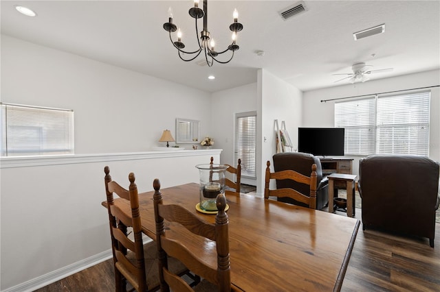 dining room featuring ceiling fan with notable chandelier and dark wood-type flooring