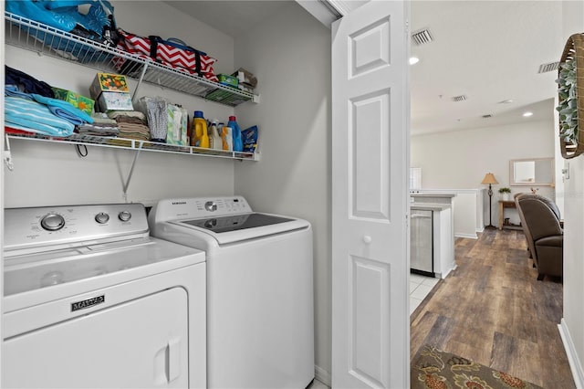 washroom featuring hardwood / wood-style flooring and washer and dryer