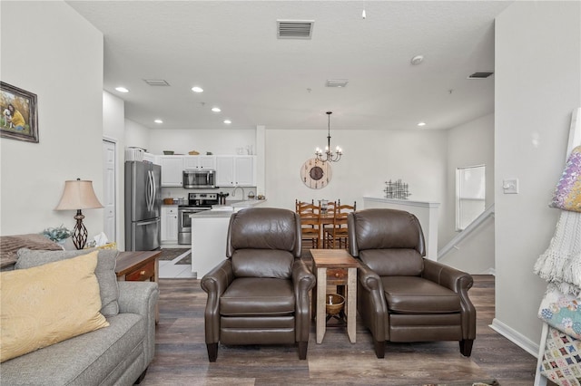 living room with dark wood-type flooring and a chandelier