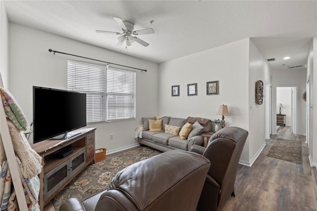 living room with a textured ceiling, ceiling fan, and dark hardwood / wood-style floors