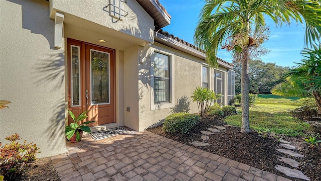 doorway to property with a lawn