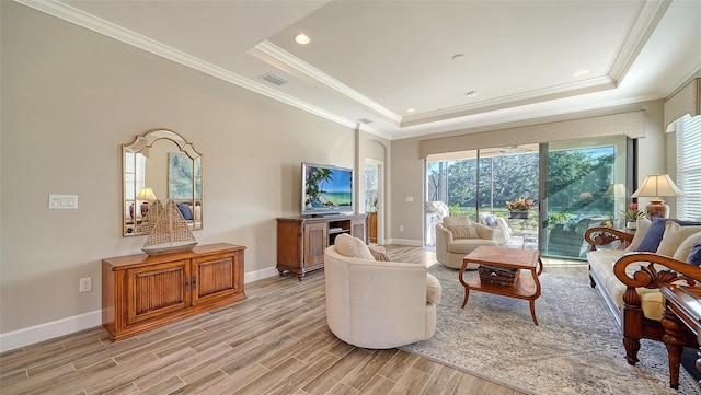 living room featuring a raised ceiling and ornamental molding