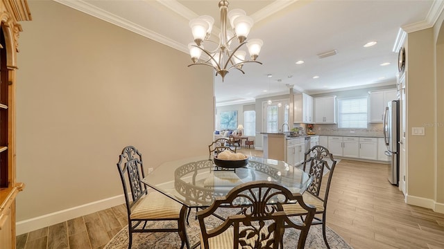 dining room featuring light hardwood / wood-style floors, ornamental molding, and an inviting chandelier