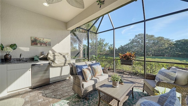 view of patio / terrace with an outdoor kitchen, ceiling fan, a lanai, and an outdoor hangout area