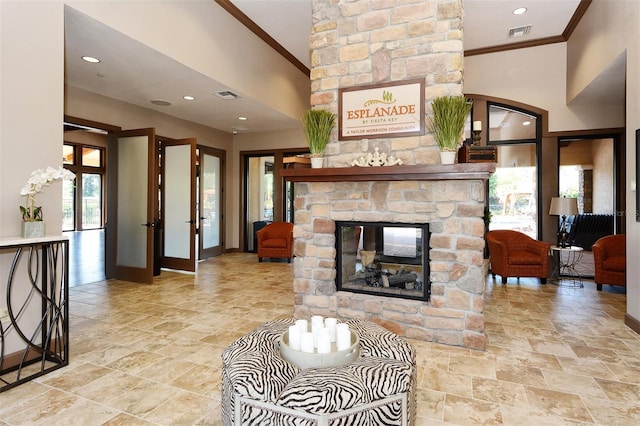 living room with a stone fireplace, crown molding, high vaulted ceiling, and french doors