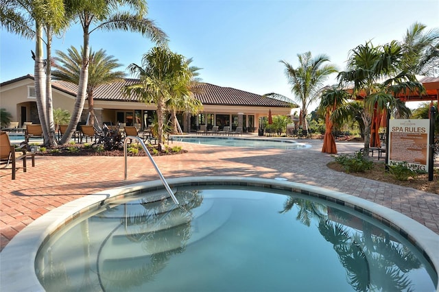 view of pool with a community hot tub and a patio