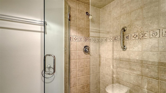 bathroom featuring a shower with shower door and toilet