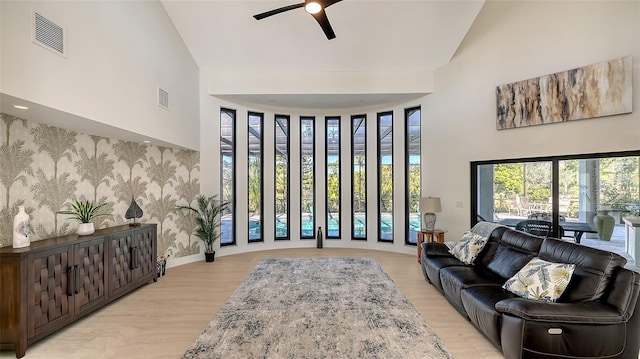 living room featuring ceiling fan, plenty of natural light, vaulted ceiling, and light hardwood / wood-style flooring