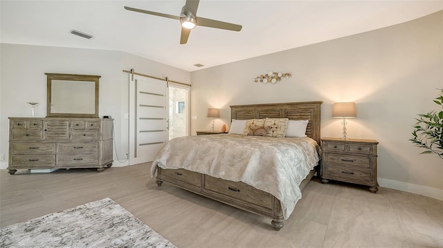 bedroom with connected bathroom, a barn door, and ceiling fan