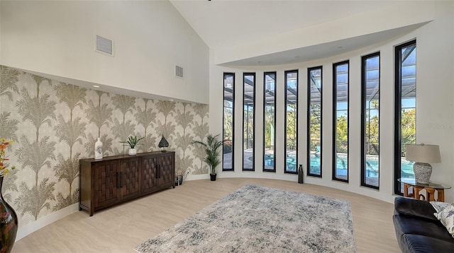 foyer with high vaulted ceiling and light wood-type flooring