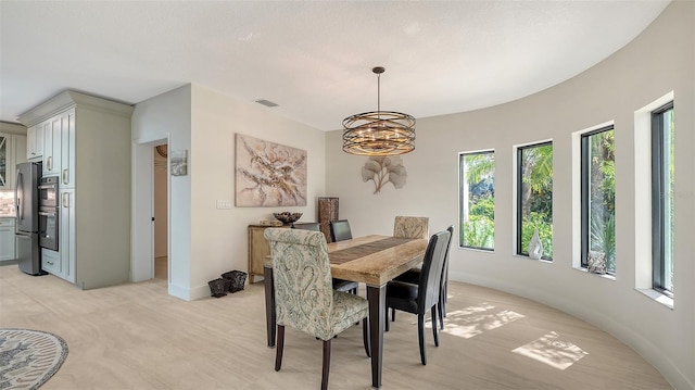 carpeted dining room featuring an inviting chandelier