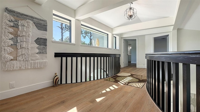 corridor featuring vaulted ceiling, light hardwood / wood-style floors, and a chandelier