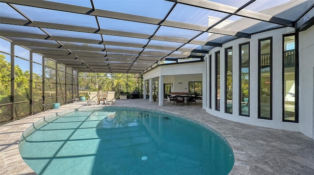 view of pool featuring glass enclosure and a patio area