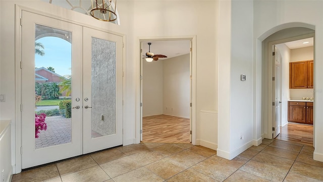 doorway featuring ceiling fan, french doors, and light tile patterned flooring