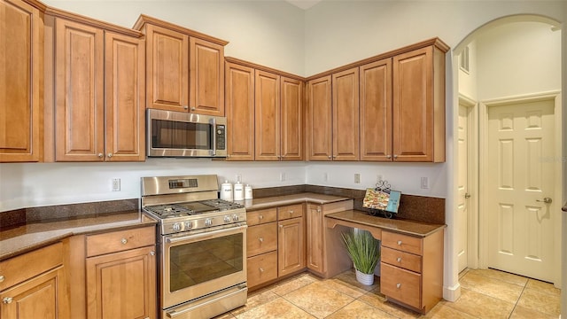 kitchen with light tile patterned flooring and appliances with stainless steel finishes