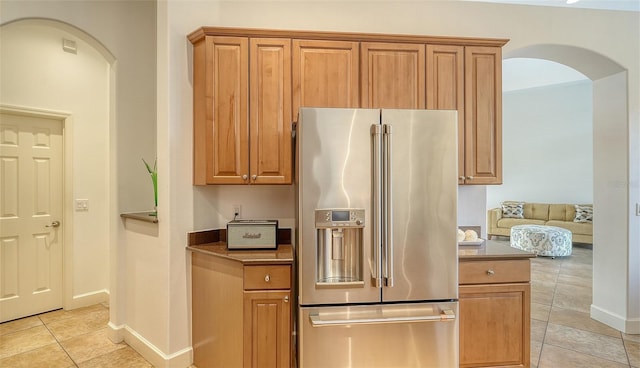 kitchen featuring high end fridge and light tile patterned floors