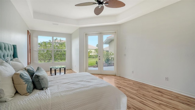 bedroom with access to outside, a raised ceiling, and ceiling fan