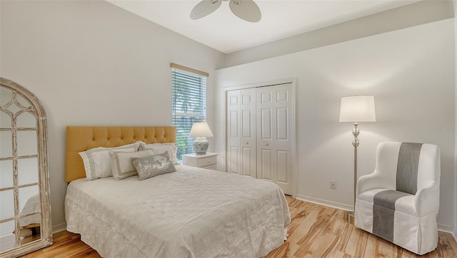 bedroom with ceiling fan, a closet, and light hardwood / wood-style floors