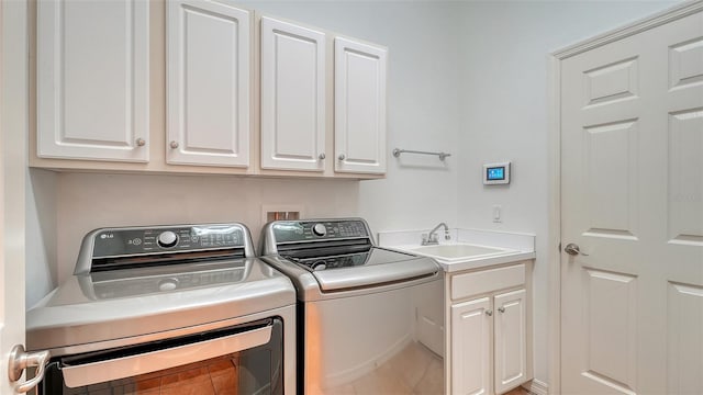 clothes washing area featuring cabinets, sink, and washing machine and clothes dryer