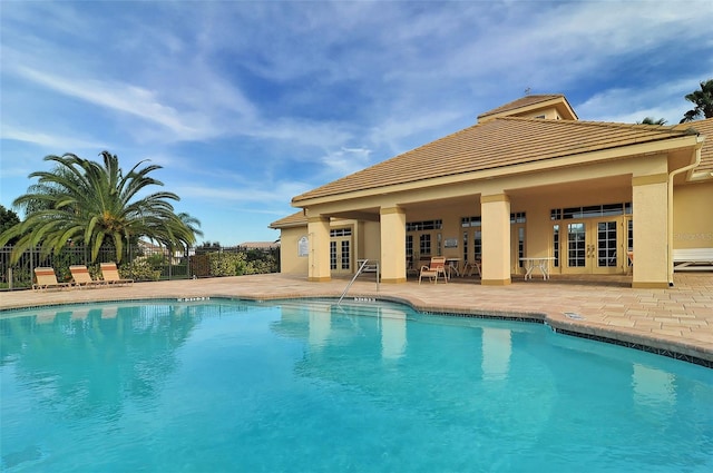 view of pool with french doors and a patio area