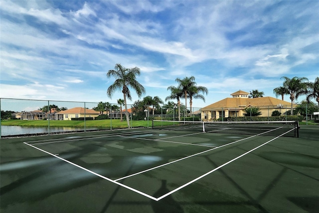 view of tennis court featuring a water view