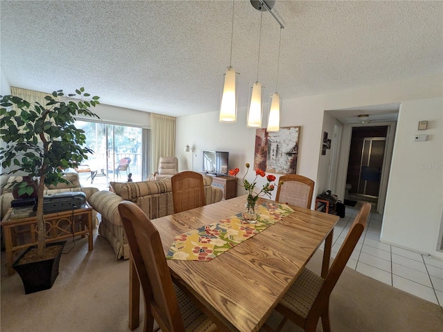 dining space featuring light tile patterned flooring and a textured ceiling