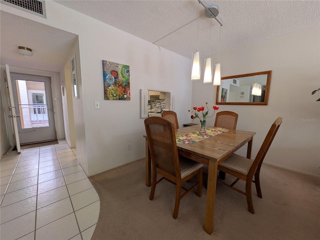 dining space with light tile patterned floors and a textured ceiling