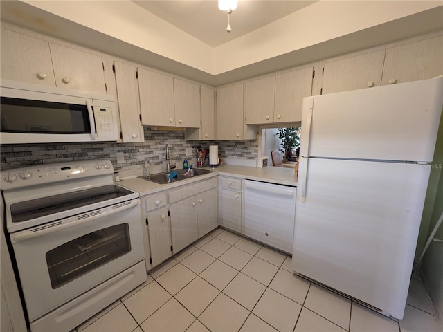 kitchen with light tile patterned floors, white appliances, tasteful backsplash, and sink