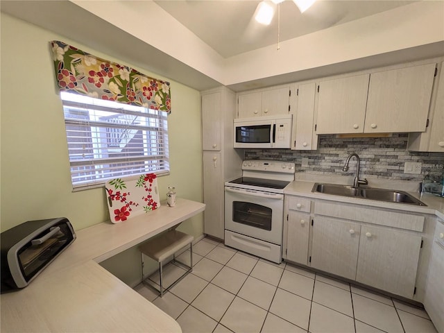 kitchen featuring decorative backsplash, light tile patterned floors, white appliances, and sink