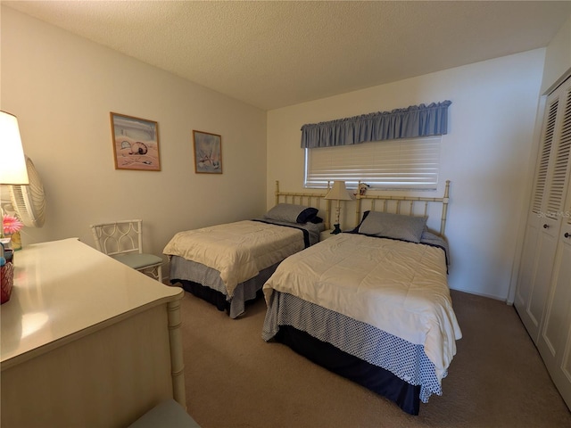 carpeted bedroom with a closet and a textured ceiling