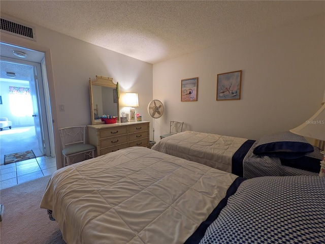 bedroom featuring light carpet and a textured ceiling