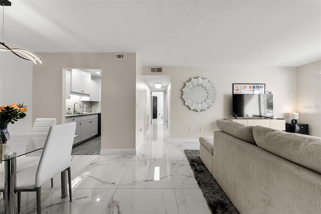 living room featuring marble finish floor, baseboards, and visible vents