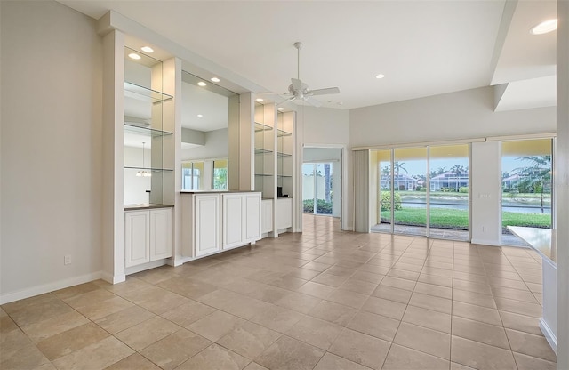 spare room featuring ceiling fan, built in features, and light tile patterned flooring