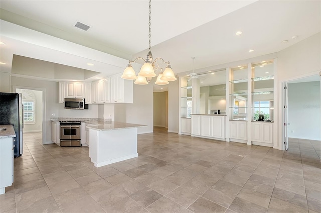 kitchen with ceiling fan with notable chandelier, kitchen peninsula, appliances with stainless steel finishes, decorative light fixtures, and white cabinetry