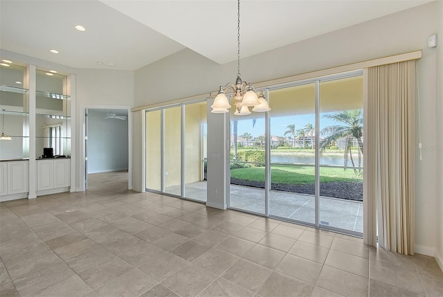 unfurnished dining area featuring light tile patterned floors, ceiling fan with notable chandelier, and a water view