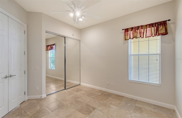 unfurnished bedroom featuring multiple windows, ceiling fan, and a closet