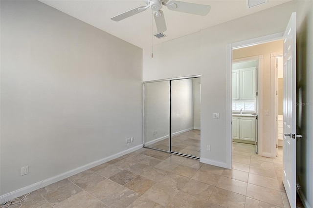 unfurnished bedroom with ceiling fan, a closet, and sink